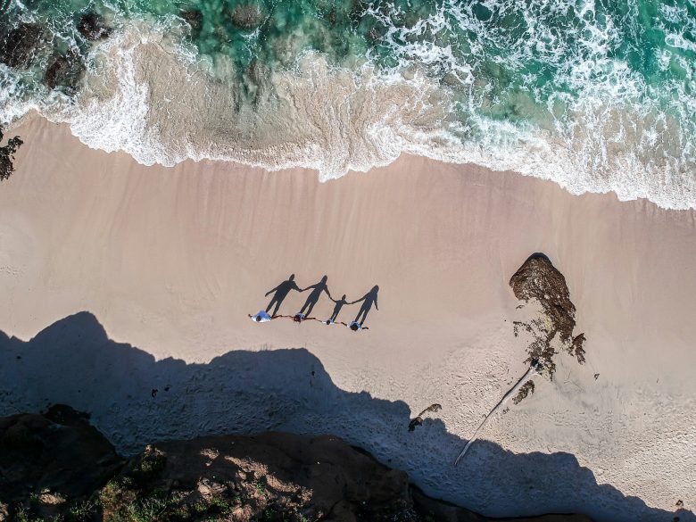 aerial photo of family on beach with waves and sand